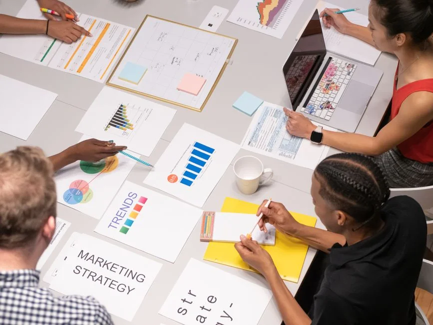 Top view of business team analyzing charts and data on paper for strategic planning.